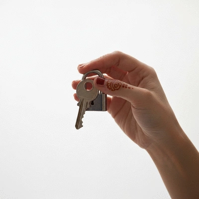 Gros plan sur une main tenant une clé et une serrure, symbolisant la sécurité